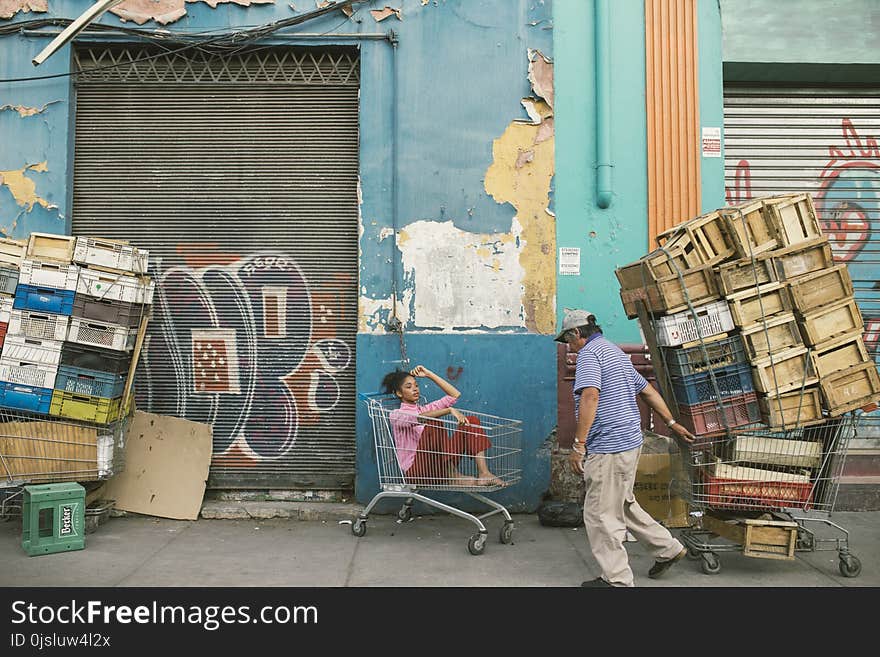 Man Wearing Gray Cap and Blue Shirt Holding Shopping Cart