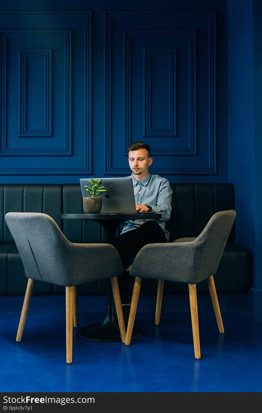 Photo of Man Using Laptop Sitting on Green Sofa