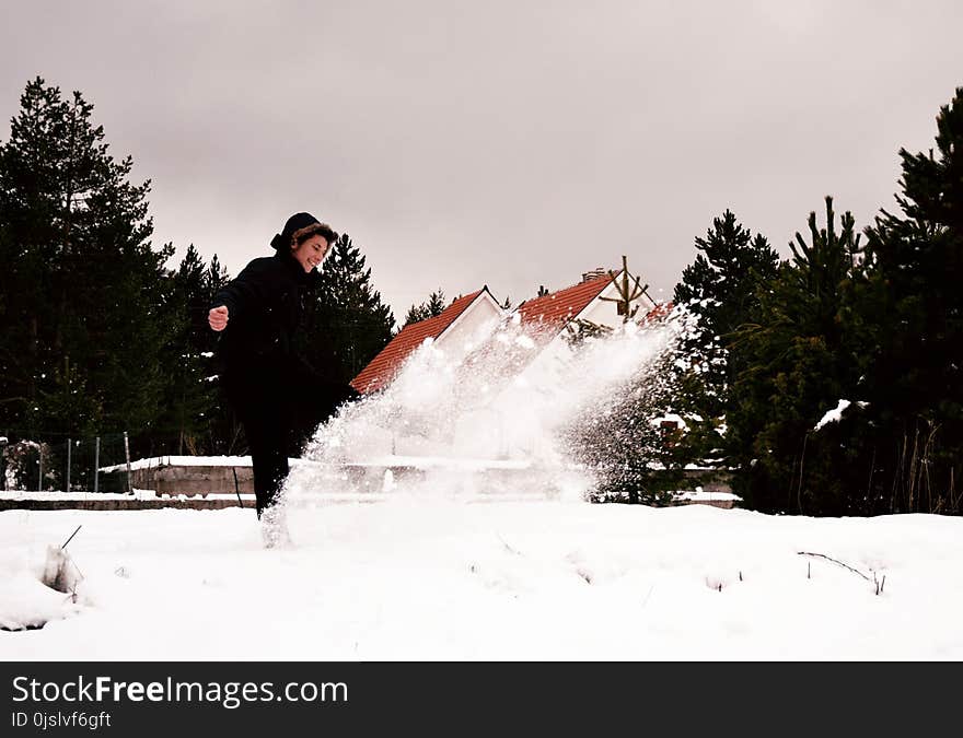 Woman Wearing Black Coat While Playing with Snow