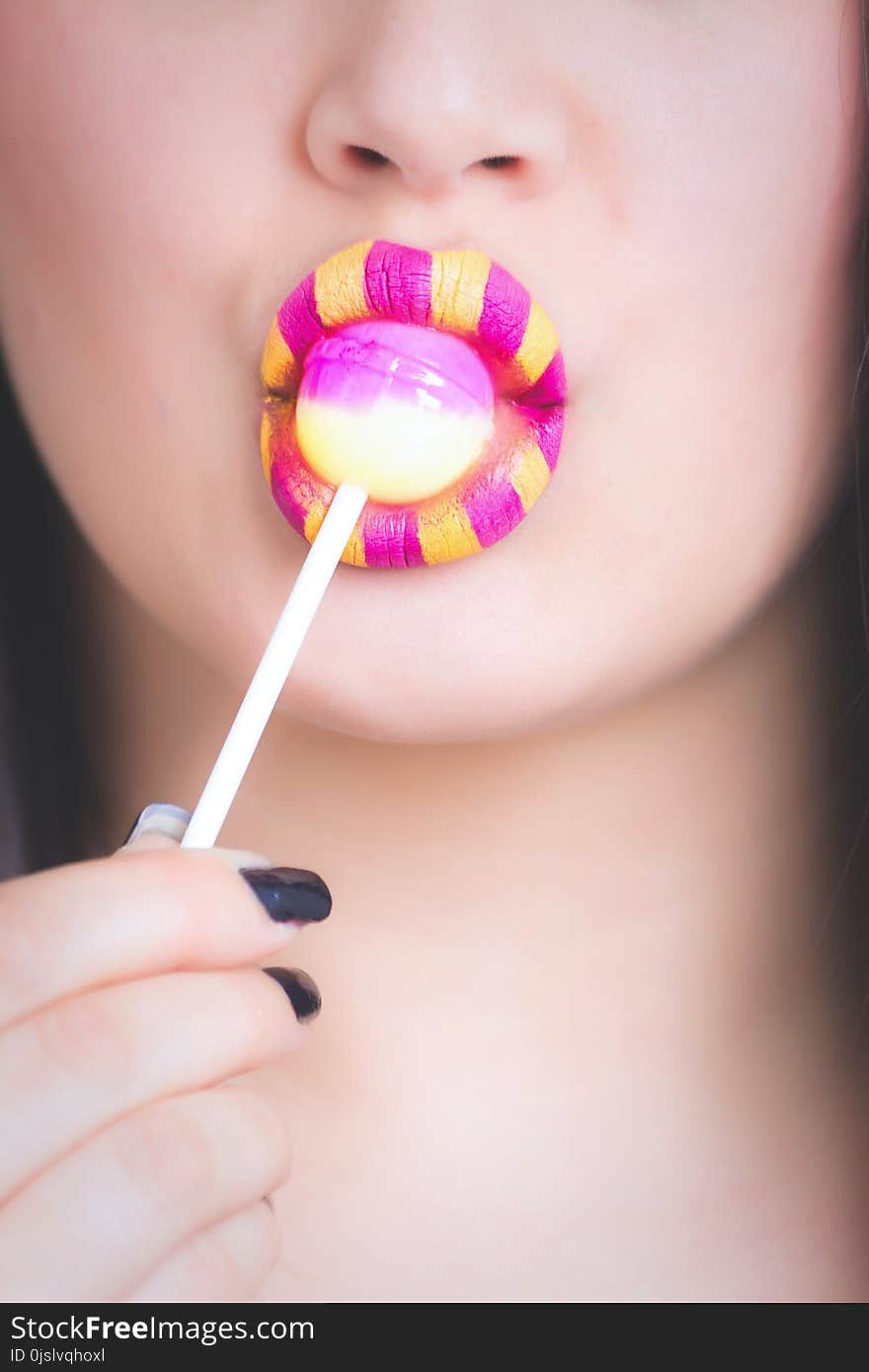 Woman Licking Pink and White Lollipop