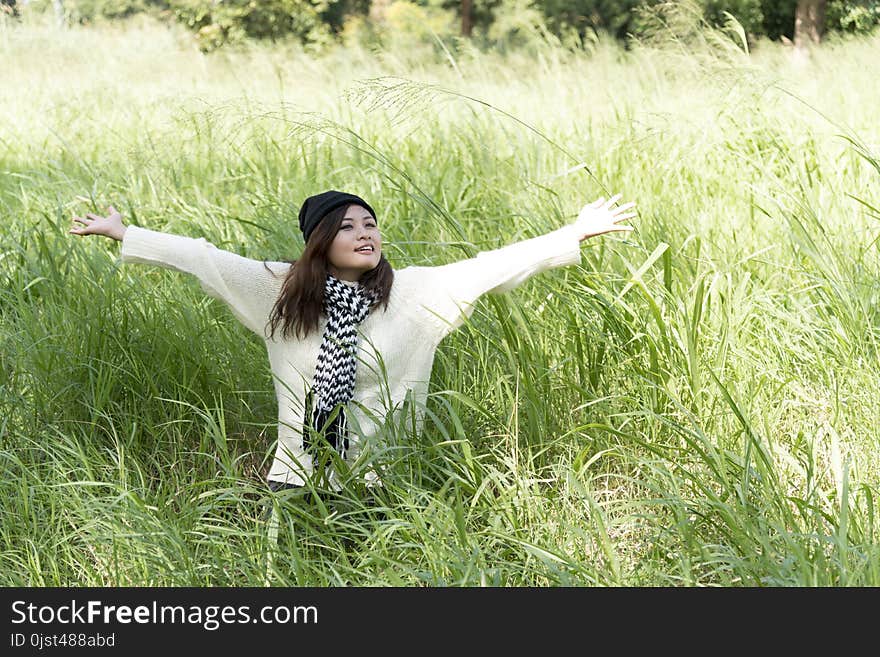 Happy woman enjoy and relax with the nature. Young beautiful woman sitting under the big tree in green forest.