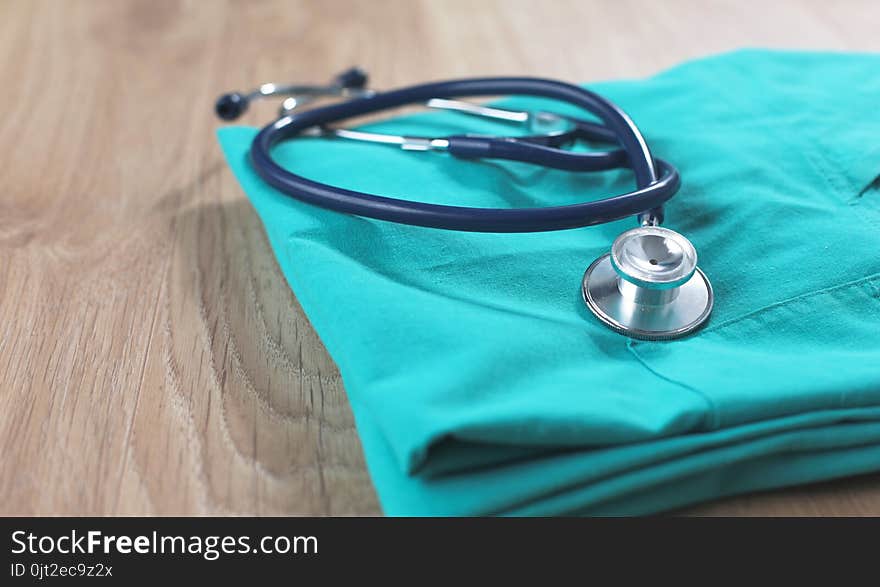 A stethoscope shaping a heart on a medical uniform, closeup.