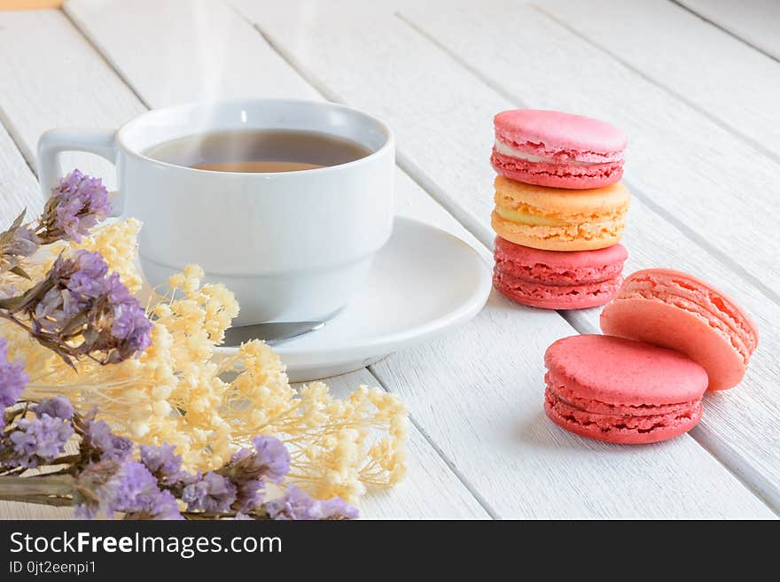 Different types color of macaroons Cup of hot tea on white wooden background Decorated with dried flowers Vintage style. Different types color of macaroons Cup of hot tea on white wooden background Decorated with dried flowers Vintage style