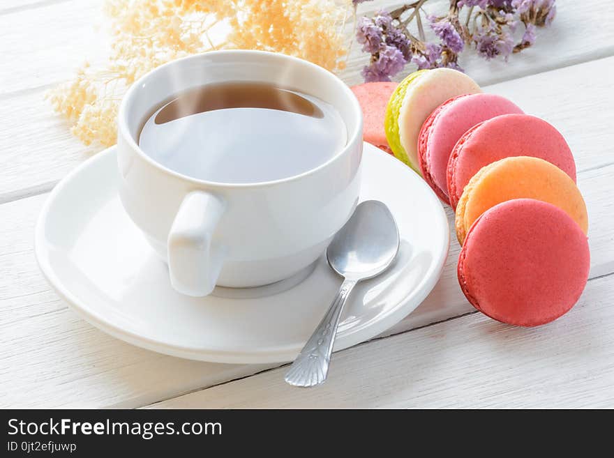 Different types color of macaroons Cup of hot tea on white wooden background Decorated with dried flowers Vintage style. Different types color of macaroons Cup of hot tea on white wooden background Decorated with dried flowers Vintage style