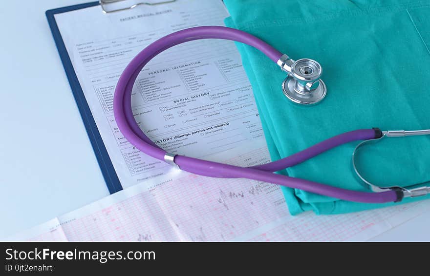 A stethoscope shaping a heart on a medical uniform, closeup