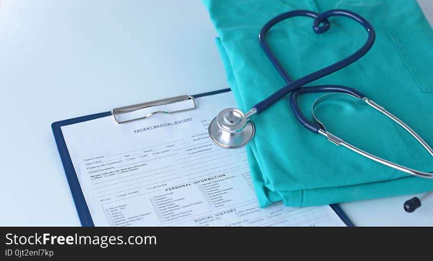 A stethoscope shaping a heart on a medical uniform, closeup.