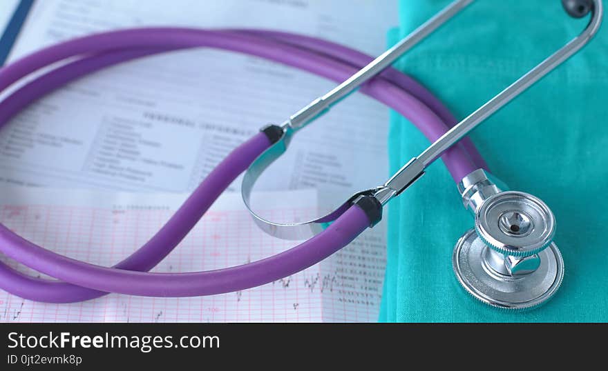 A stethoscope shaping a heart on a medical uniform, closeup.