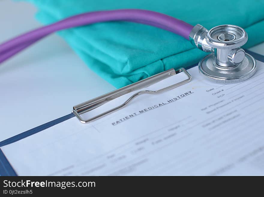 A stethoscope shaping a heart on a medical uniform, closeup.