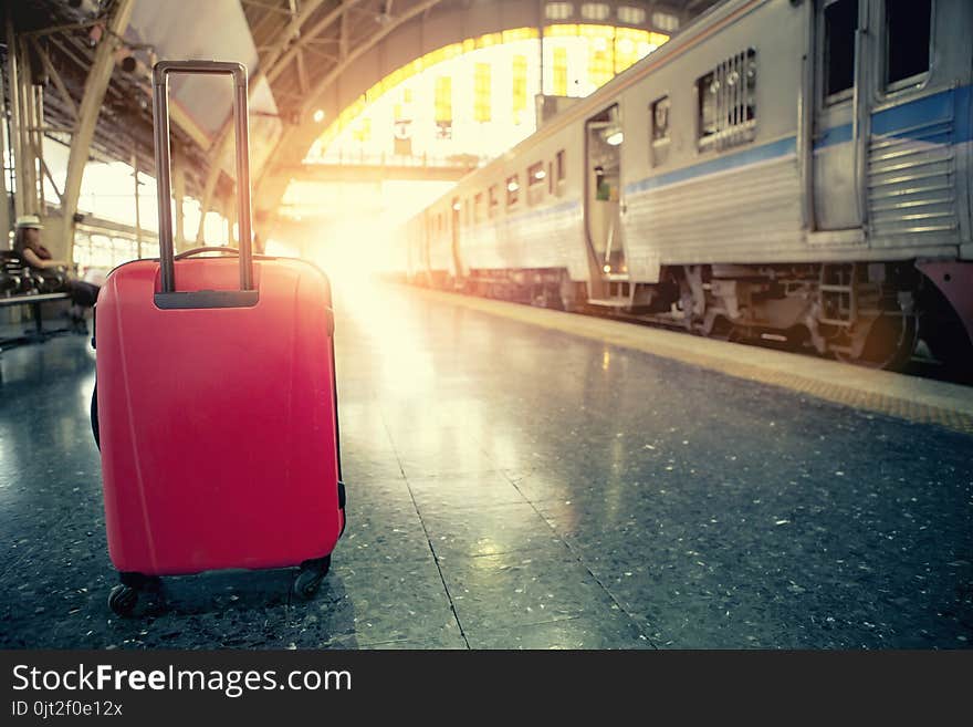 Red traveling luggage in trains station