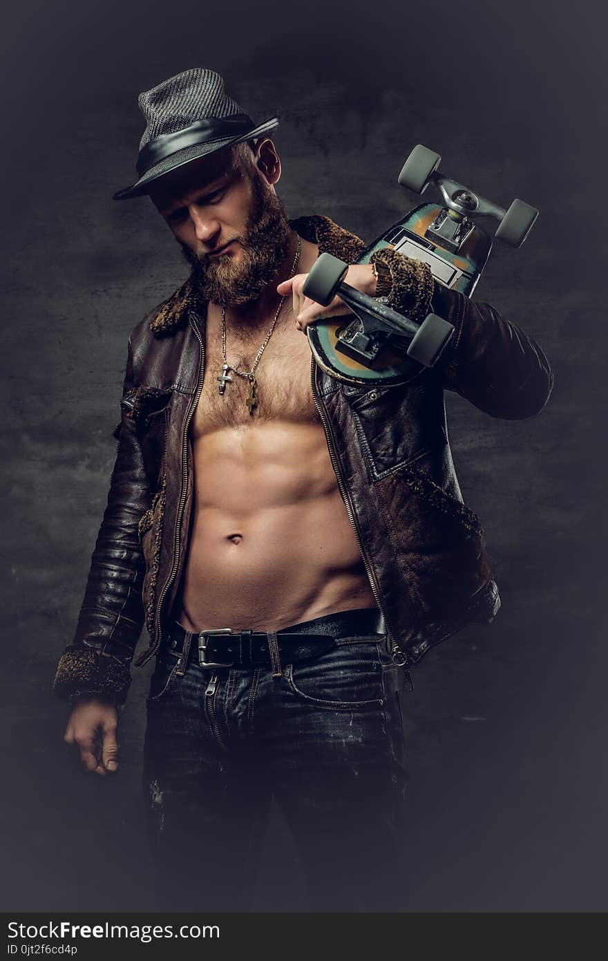 Bearded Male Dressed In Leather Jackett Holds Skateboard.