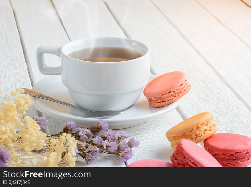 Different Types Color Of Macaroons With Cup Of Hot Tea On White