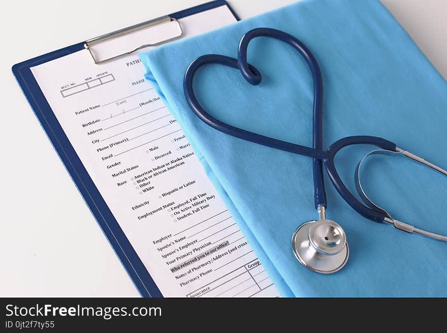 A stethoscope shaping a heart on a medical uniform, closeup.