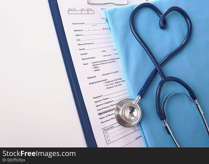 A stethoscope shaping a heart on a medical uniform, closeup