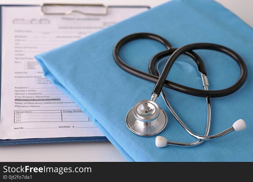 A stethoscope shaping a heart on a medical uniform, closeup