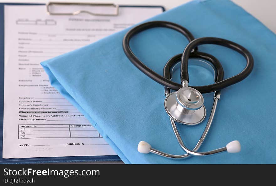 A stethoscope shaping a heart on a medical uniform, closeup.