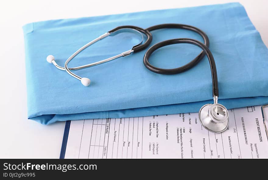 A stethoscope shaping a heart on a medical uniform, closeup.