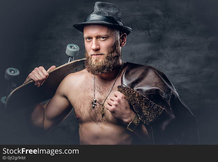 Bearded man wearing a leather jacket on naked torso.