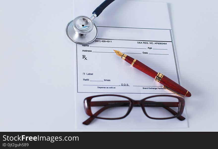 Doctor`s workspace working table with patient`s discharge blank paper form, medical prescription, stethoscope on desk.