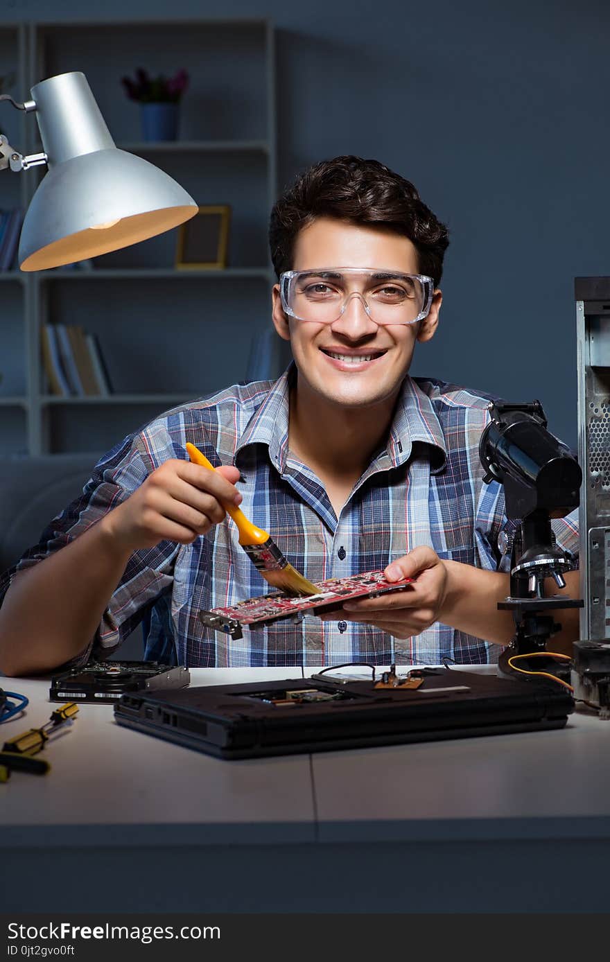 The computer repair man cleaning dust with brush