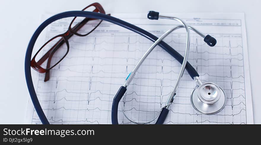 Stethoscope on cardiogram concept for heart care on the desk.blue toned images