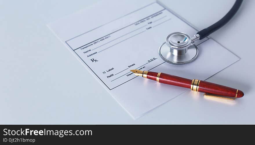 Doctor`s workspace working table with patient`s discharge blank paper form, medical prescription, stethoscope on desk