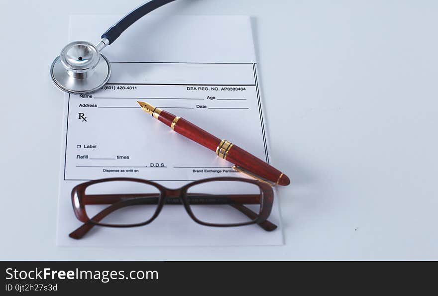 Doctor`s workspace working table with patient`s discharge blank paper form, medical prescription, stethoscope on desk.