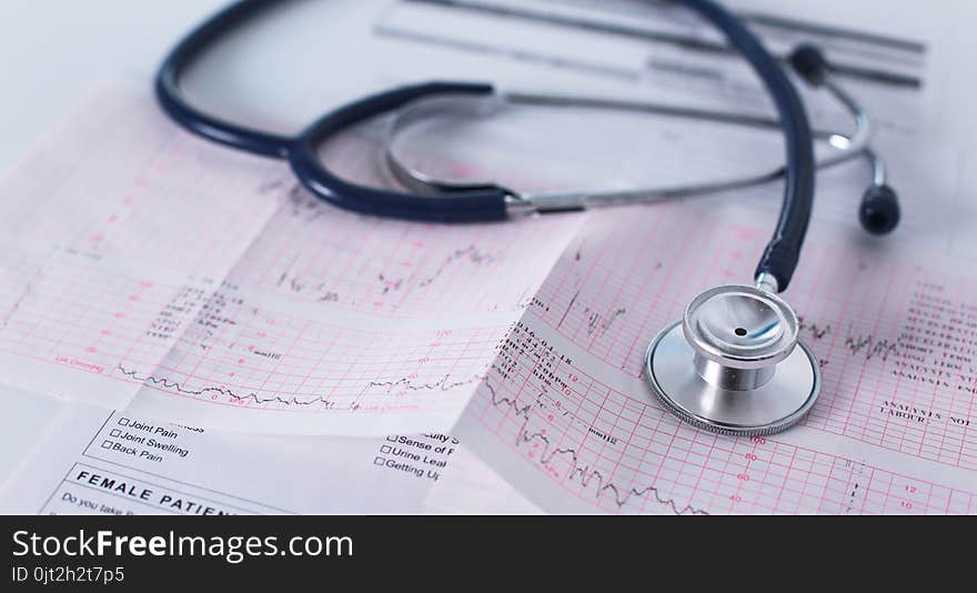 Stethoscope on cardiogram concept for heart care on the desk.blue toned images