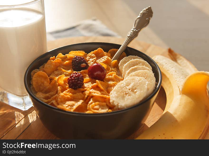 Cornflakes Breakfast Cereal In The Bowl With Glass Of Milk, Berries And Banana On Wood Table