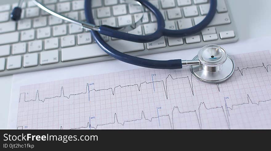 Stethoscope on cardiogram concept for heart care on the desk.blue toned images.