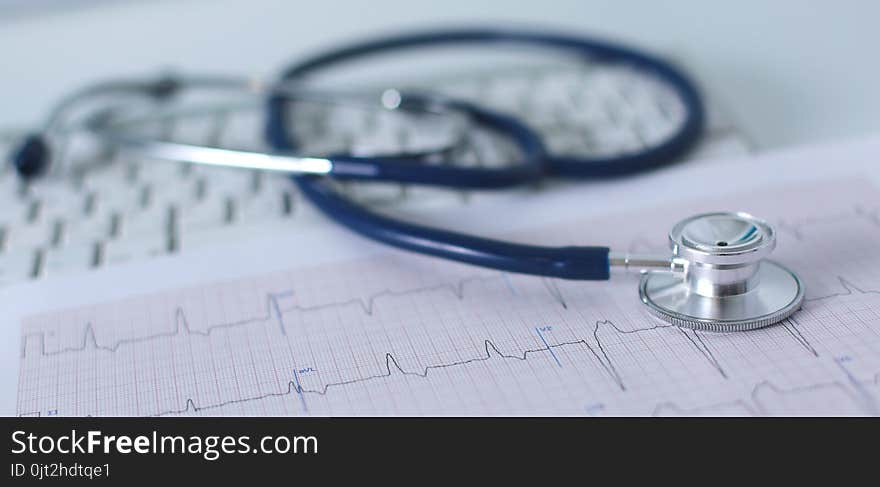 Stethoscope on cardiogram concept for heart care on the desk.blue toned images.