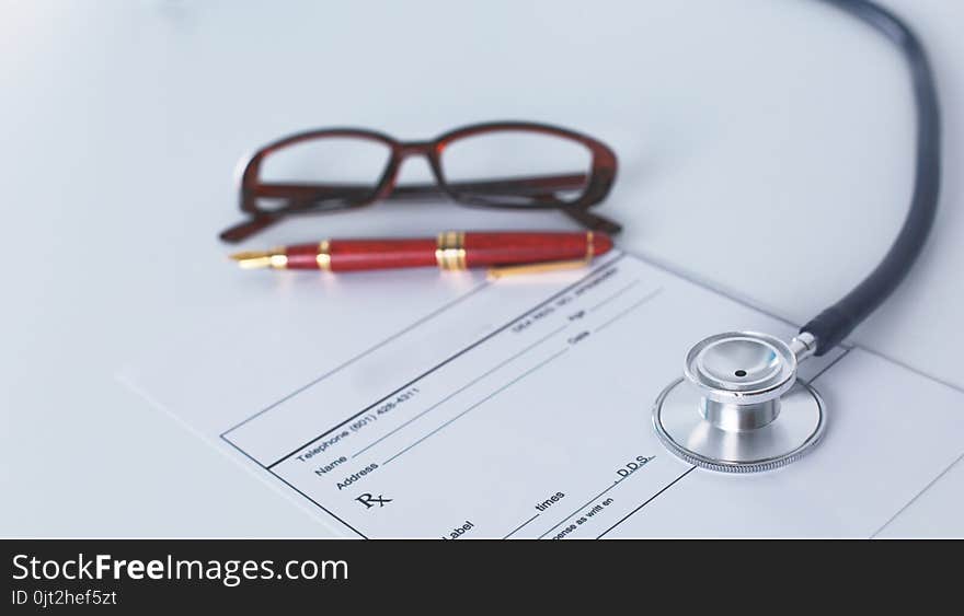 Doctor`s workspace working table with patient`s discharge blank paper form, medical prescription, stethoscope on desk