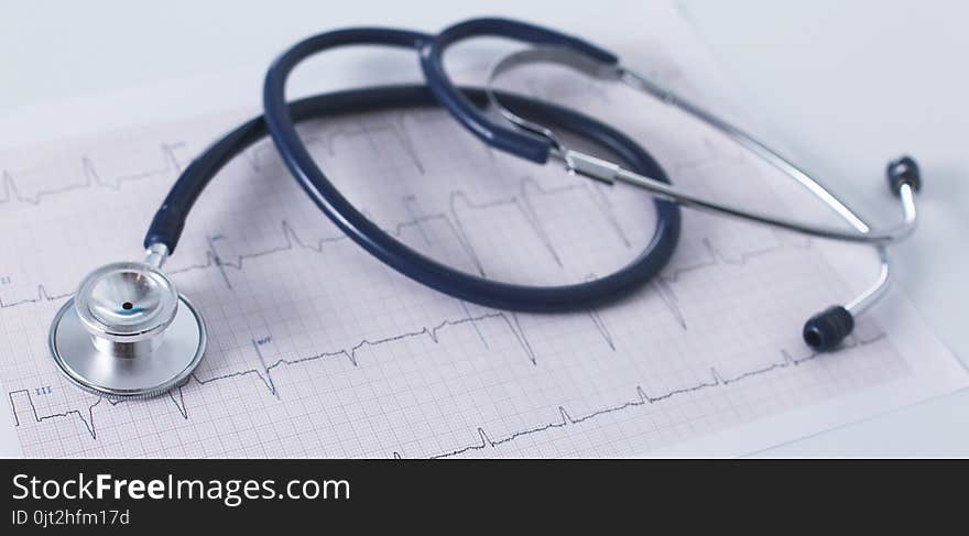 Stethoscope on cardiogram concept for heart care on the desk.blue toned images