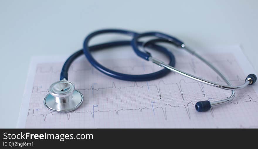 Stethoscope on cardiogram concept for heart care on the desk.blue toned images.