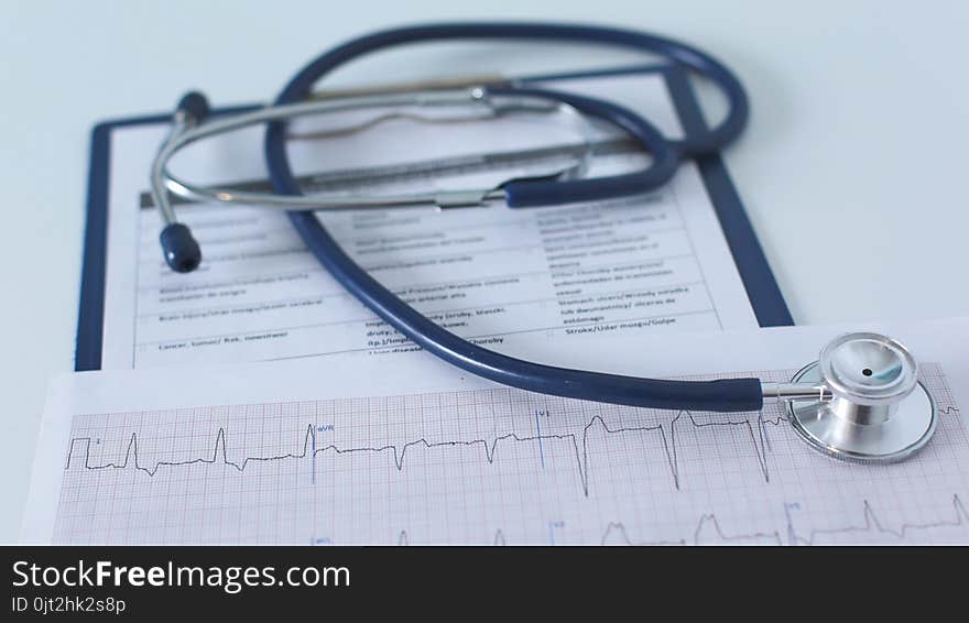 Stethoscope on cardiogram concept for heart care on the desk.blue toned images.