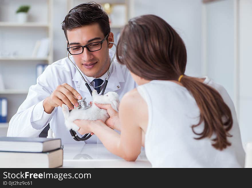 The woman with pet rabbit visiting vet doctor