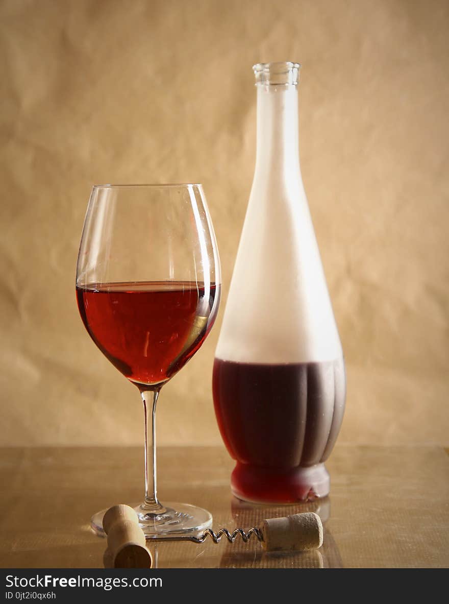 Still life with glass and bottle of wine, cheese and grapes.