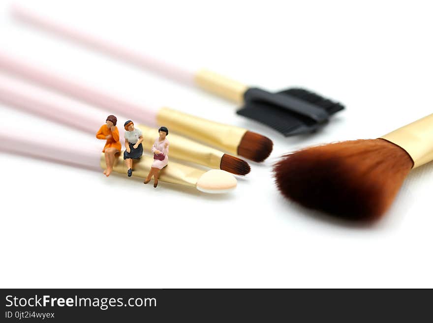 Miniature people: womans and friend sitting on cosmetic bottle using as background business, healthcare and beauty concept.