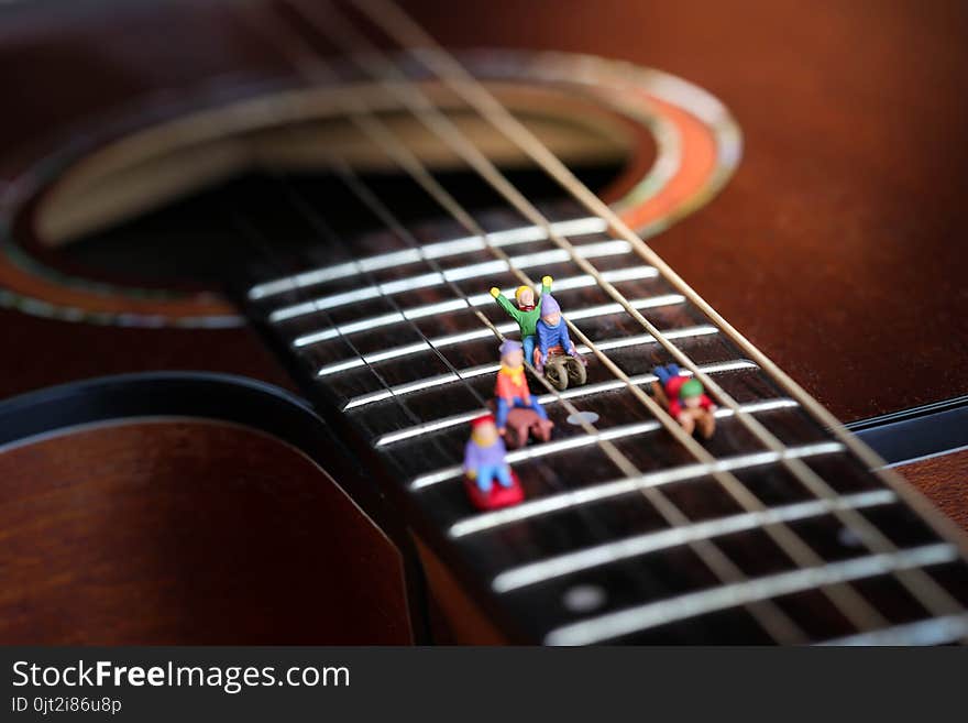 Miniature people : Child having fun to play slider with acoustic guitar,time of relax or music relax,stationary,education concept.