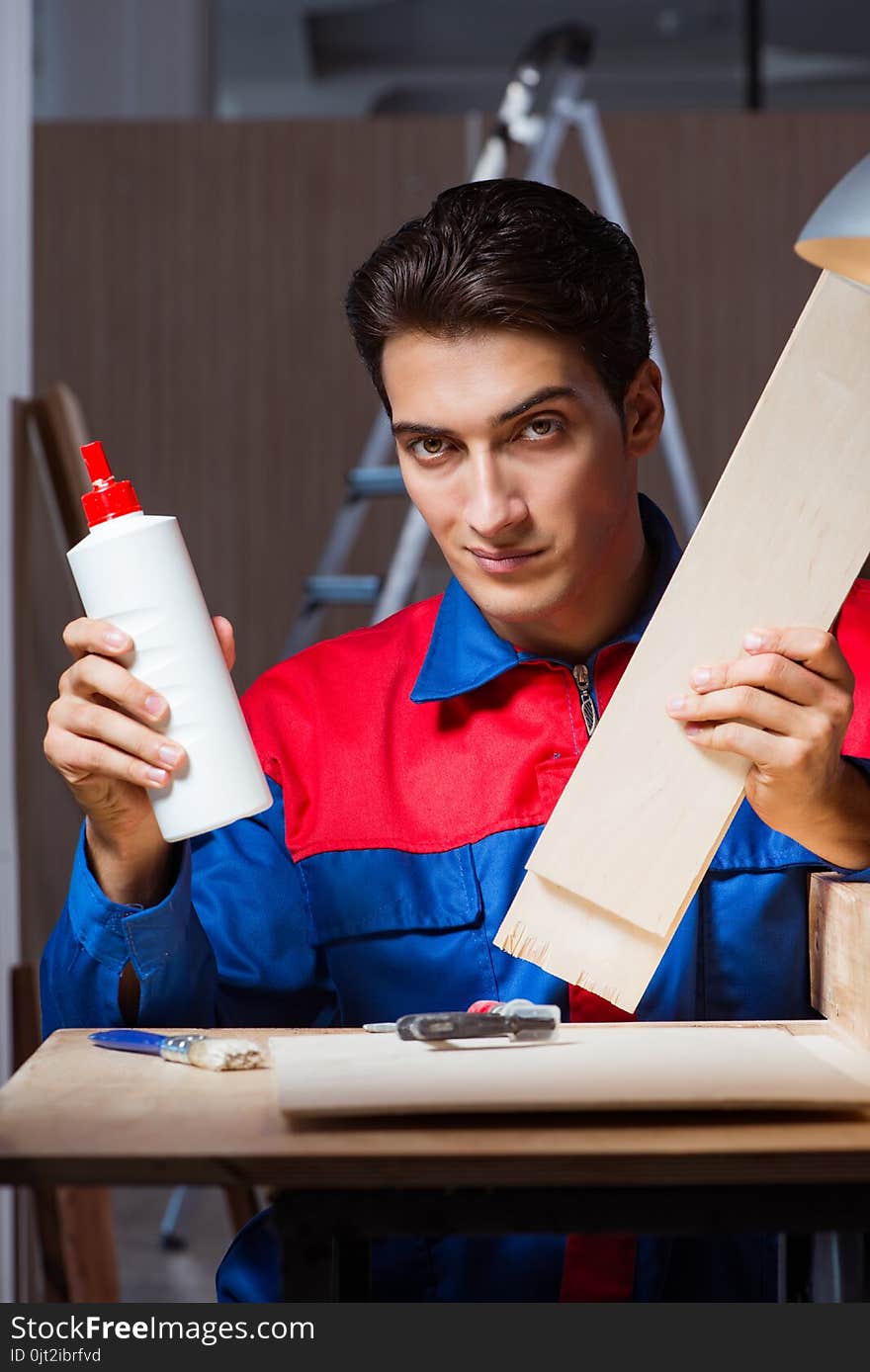 The Young Man Gluing Wood Pieces Together In Diy Concept