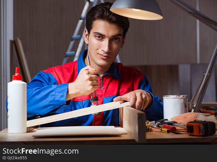 The young man gluing wood pieces together in diy concept