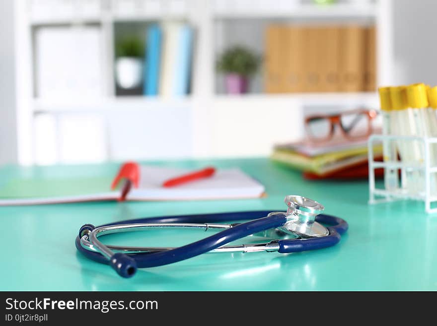 Doctor`s workspace working table with patient`s discharge blank paper form, medical prescription, stethoscope on desk