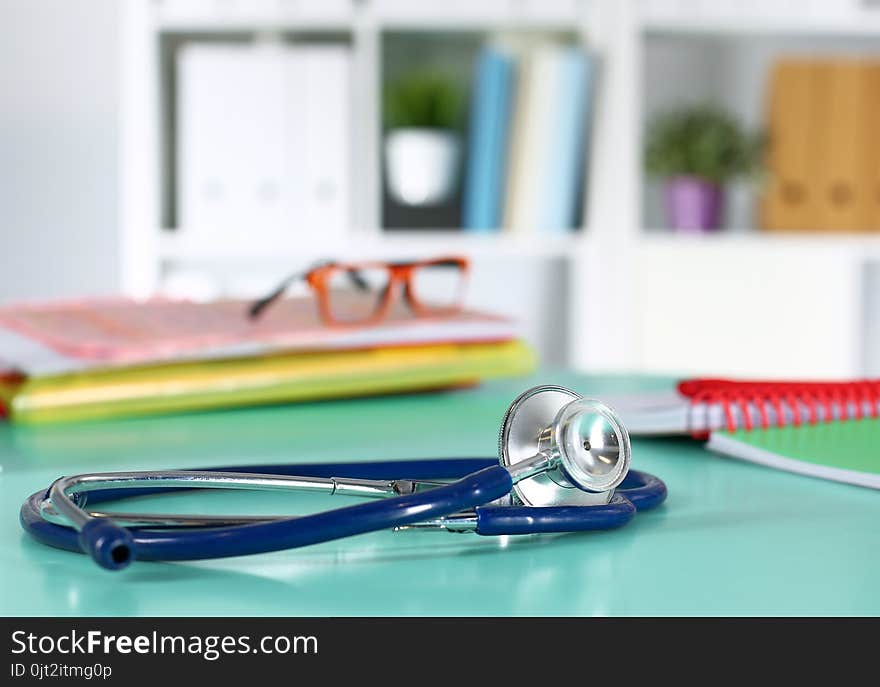 Doctor`s workspace working table with patient`s discharge blank paper form, medical prescription, stethoscope on desk.