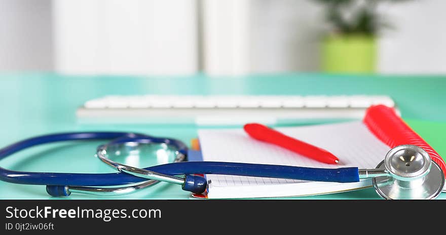 Doctor`s workspace working table with patient`s discharge blank paper form, medical prescription, stethoscope on desk.