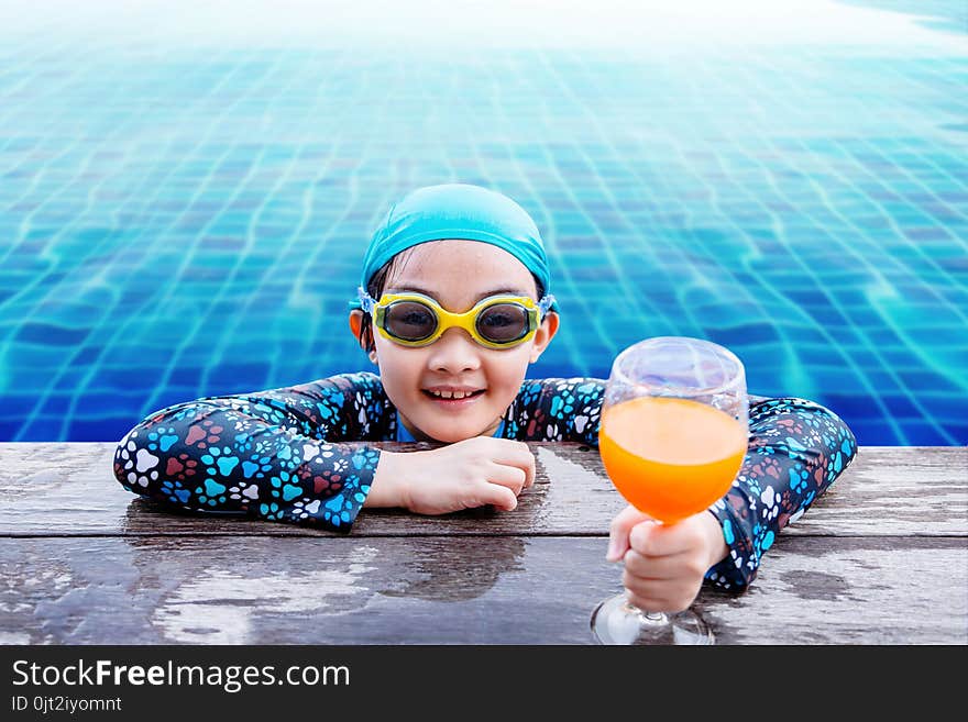 Happy Children at the Swimming Pool Side, Girl Relaxing with Summer Drink, Smile and Looking at Camera, Blue Water as background