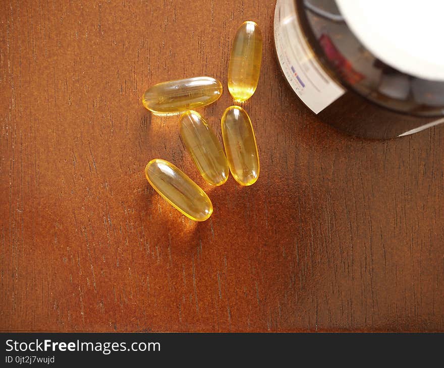 Vitamin Capsules on wood background