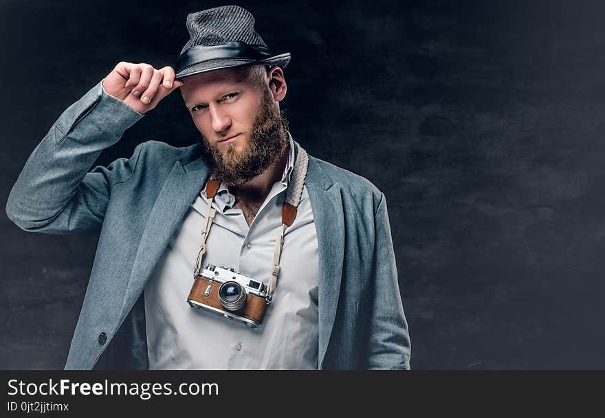 Bearded male holds vintage slr photo camera.