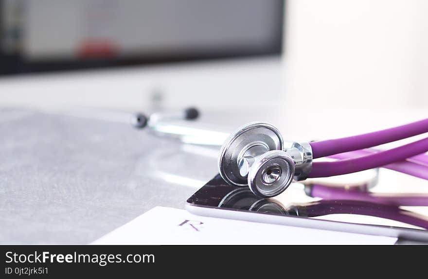 Doctor`s workspace working table with patient`s discharge blank paper form, medical prescription, stethoscope on desk