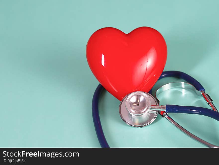 Red heart with stethoscope on blue wooden background. Copy space. Valentines day.