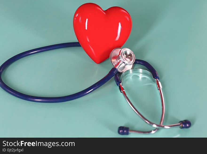 Red heart with stethoscope on blue wooden background. Copy space. Valentines day.