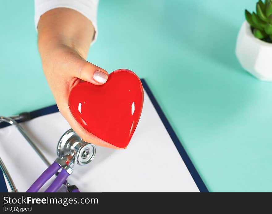 Female Doctor With The Stethoscope Holding Heart